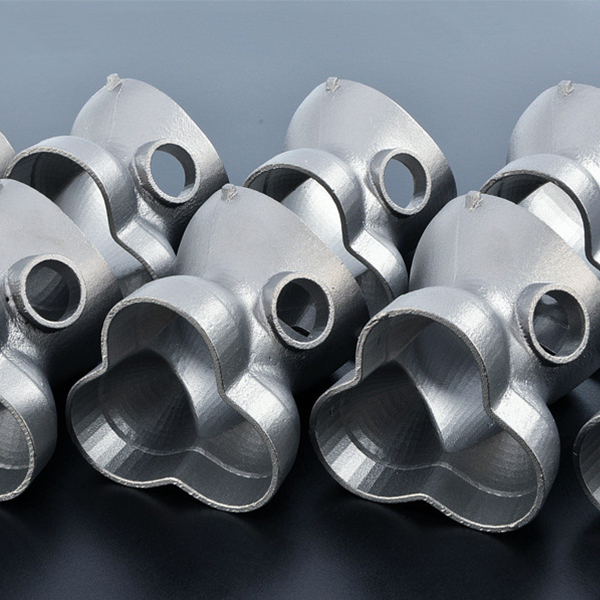 Una colecci&oacute;n de accesorios de tuber&iacute;a met&aacute;licos plateados brillantes con uniones de tres v&iacute;as, dispuestos muy juntos sobre una superficie negra reflectante. Cada accesorio tiene bordes lisos y redondeados y aberturas circulares en los extremos, lo que ejemplifica la precisi&oacute;n de las empresas de fabricaci&oacute;n OEM y ODM en China